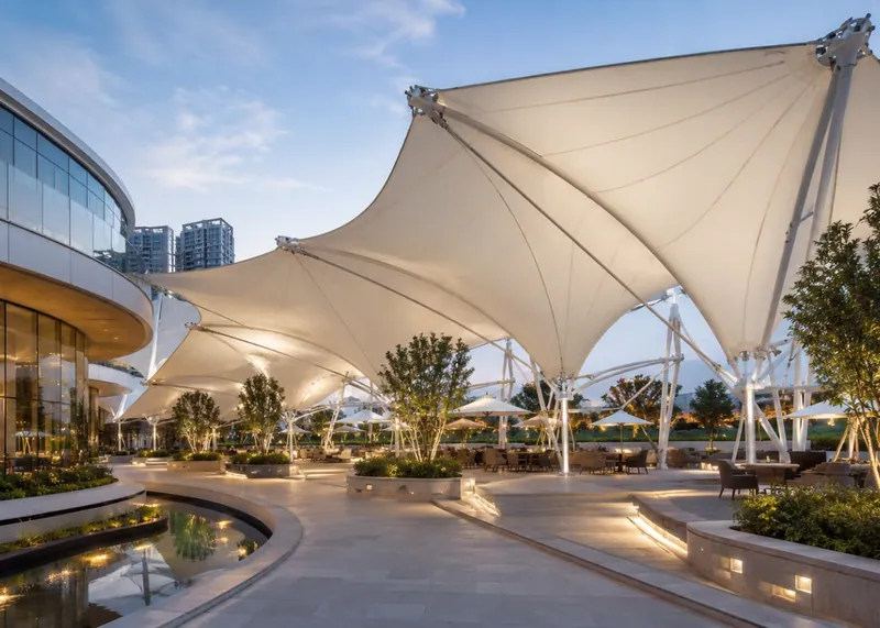 White tensile canopies beside a development with outdoor spaces