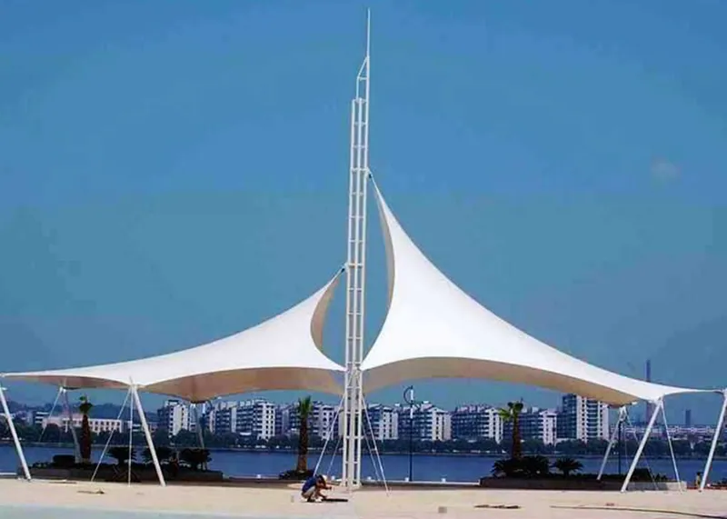 Two-wing tensile fabric canopy beside the water