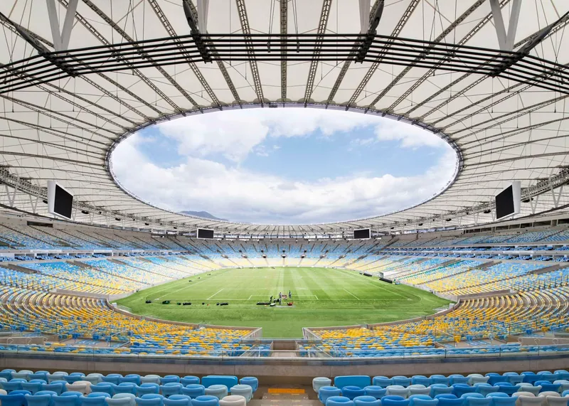 Interior view of a stadium with a membrane roof and central opening to the sky