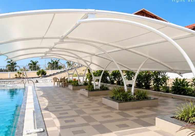 White canopy beside a pool and terrace