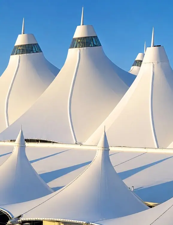 A sequence of large white tensile roofs